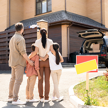 family holding eachother front of a house