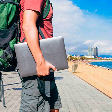 a man walking while holding a laptop near beach a man walking while holding a laptop near beach